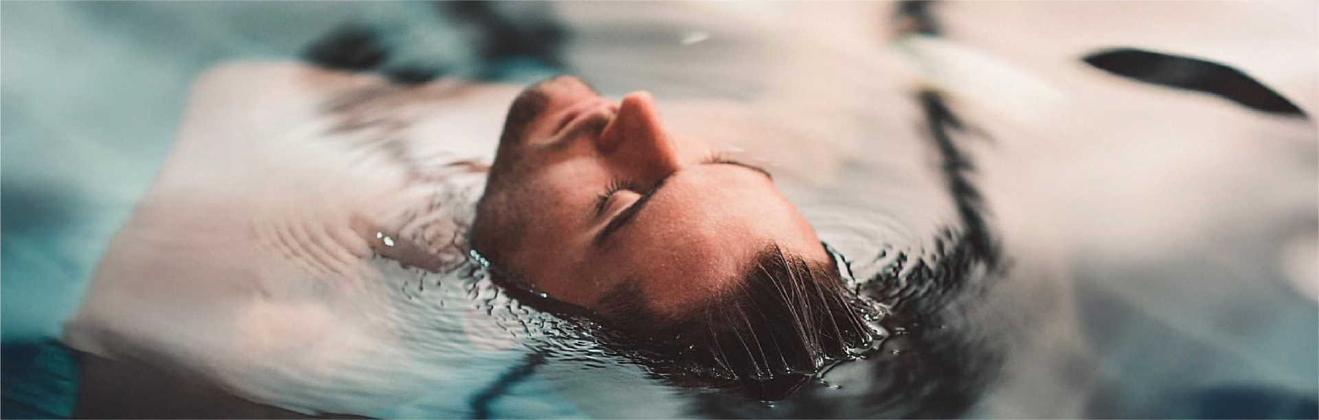 A man floating peacefully on the surface of water
